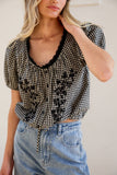 VIDA MOULIN black and white gingham blouse with floral embroidery, puff sleeves, and scoop neckline.