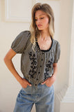 VIDA MOULIN black and white gingham blouse with floral embroidery, puff sleeves, and scoop neckline. Model wears size S.