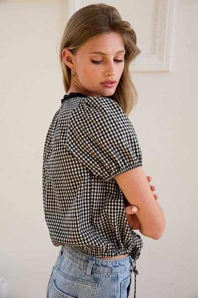 VIDA MOULIN black and white gingham blouse with floral embroidery, puff sleeves, and scoop neckline.