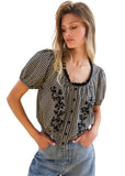 VIDA MOULIN black and white gingham blouse with floral embroidery, puff sleeves, and scoop neckline.