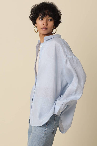 VIDA MOULIN Jada light blue linen oversized shirt with drop shoulders and button front, paired with jeans.