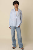 VIDA MOULIN light blue linen Jada shirt with relaxed oversized fit and drop shoulder, worn by a model with a cream tank top and light wash jeans.
