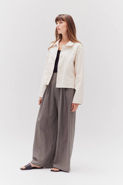 VIDA MOULIN cream twill cotton jacket with a relaxed fit, button front, and two chest pockets. Model wears it with grey wide-leg pants.